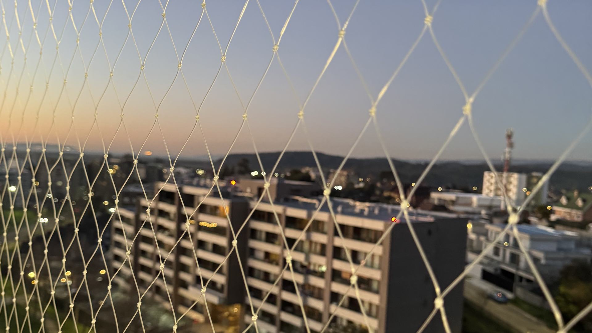 Malla de seguridad instalada en balcón, vista al atardecer en el Biobío