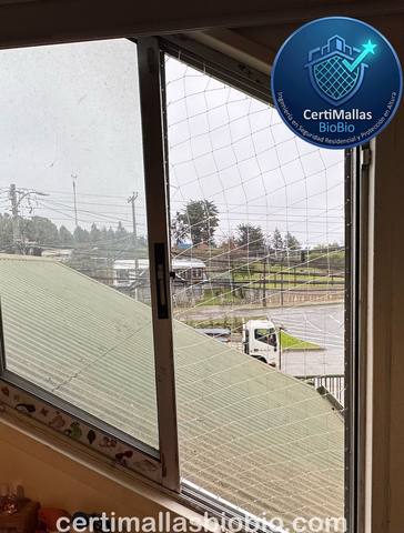 Malla de seguridad instalada en ventana en día lluvioso