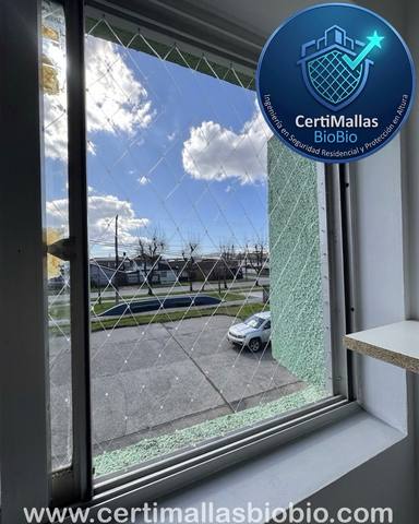 Malla de seguridad en balcón con baranda de vidrio al atardecer
