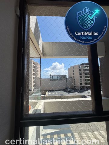 Malla de seguridad instalada en ventana con vista a edificios