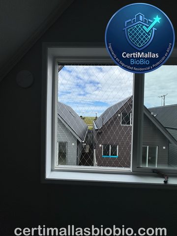Malla de seguridad instalada en ventana de dormitorio con vista a casas vecinas