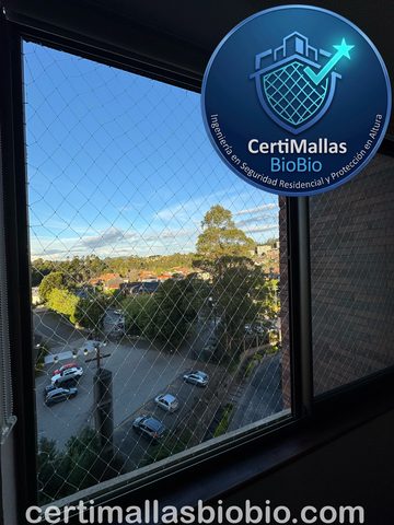 Malla de seguridad instalada en ventana con vista a árboles y calle