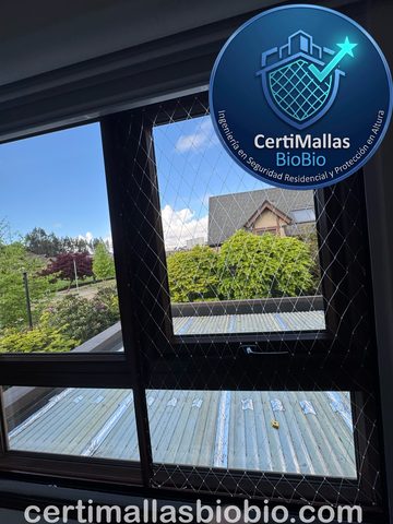 Malla de seguridad instalada en ventana con vista a jardín