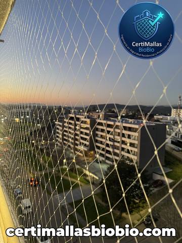 Malla de seguridad instalada en balcón con vista a la ciudad al atardecer